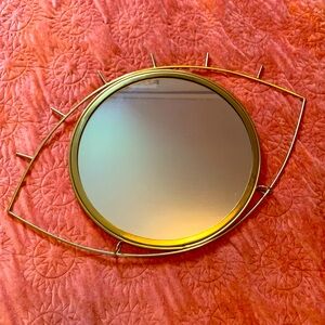 Gold, metal eye shaped wall mirror